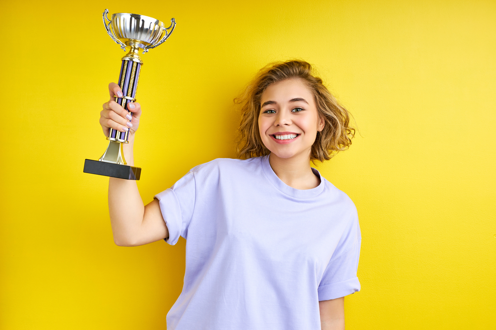 A woman holding a personalized trophy.